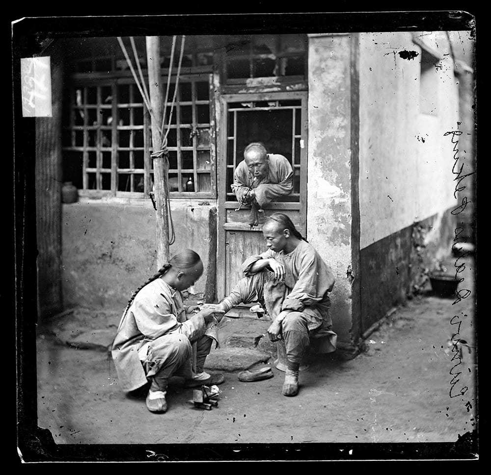 Fig. 5. One of a group of four ‘medical men’, the photograph shows a Pekingese chiropodist tending one patient, whilst another waits his turn. It appears in Illustrations of China, IV, plate 11. Photograph by John Thomson, negative no. 727. Credit: Wellcome Collection. CC.BY