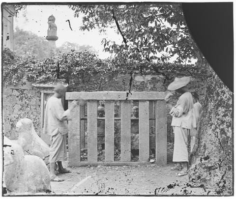 Photograph by C.F. Moore. Two men posed, seemingly throwing stones at iron figures, at Yue Fei Temple (Yuewang Temple 岳王廟), West Lake, Hangzhou. This photograph (negative ref no: J-00496) is listed in Moore’s ‘China in the Time of General Gordon’ lecture notebook: “13. Iron figures in stone cages, being the conspirators who compassed the death of Yoh Fei, his son and family.” See Ar01-016 (note the sculpture on a column in both images).