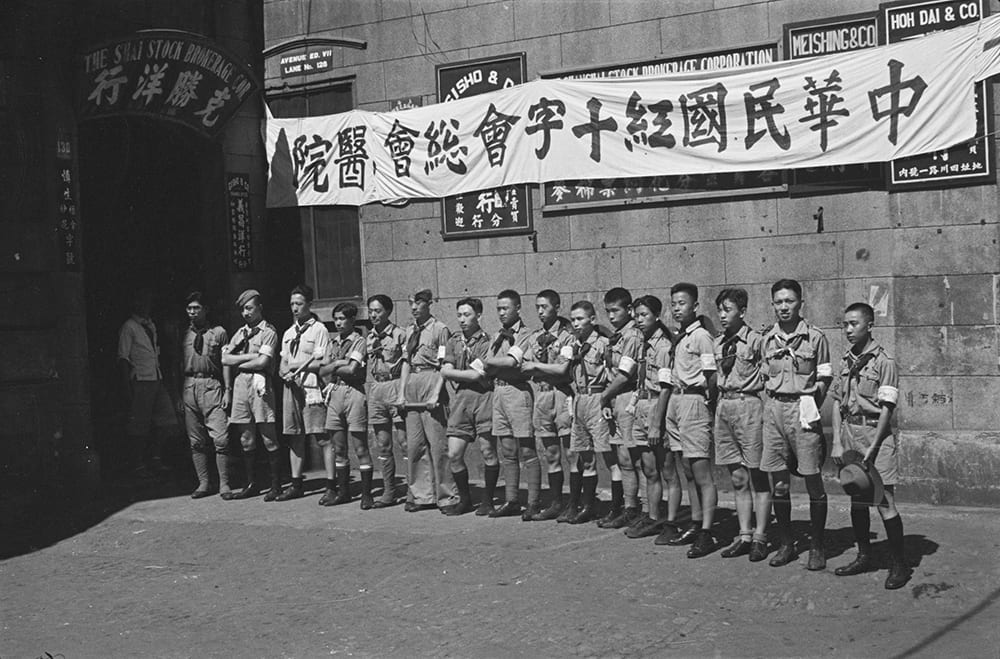 Boy scouts outside Shanghai Stock Brokerage Corporation office (serving as a red Cross hospital), Shanghai. Photograph by Malcolm Rosholt. HPC ref: Ro-n0156.
