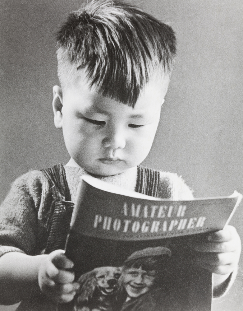 A portrait of a boy reading ‘Amateur Photographer’ magazine, 1940s/1950s (HPC ref: Ha-s056), from the extensive Tita and Gerry Hayward Collection (DM2830), which includes Basil Edward (Dick) Foster Hall (1894-1975) material. A few images in this collection have been published on the HPC web site.